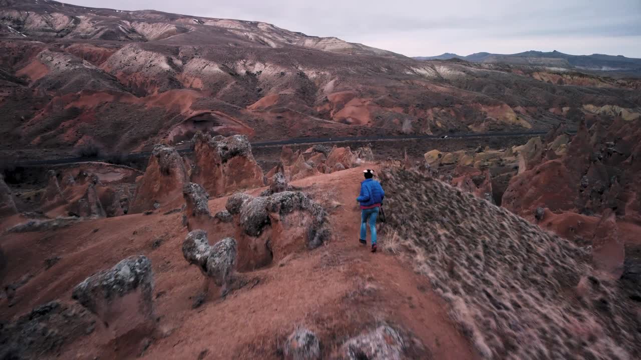 상상의 계곡, 데브렌트 카파도키아, 터키의 요정 굴뚝 사이를 걷는 백인 여성 관광객의 공중 전망