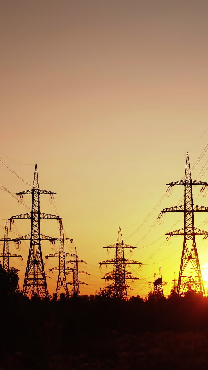 Technogenics landscape, urban. The energy of the pole in the rays of the rising sun. Posts for the transfer of high lead. Steel electric pillars concept. Vertical video