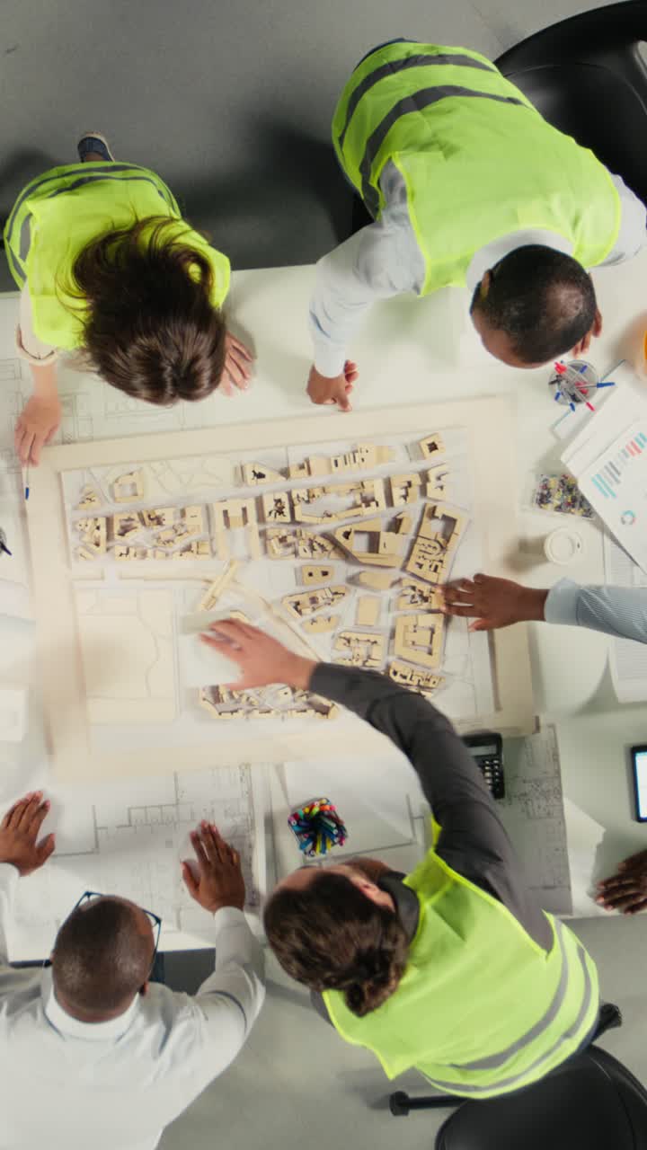 Vertical Video Top down view zoom in of real estate professionals using architectural software