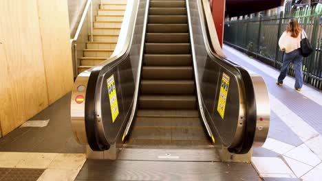 person walking near escalator at train station