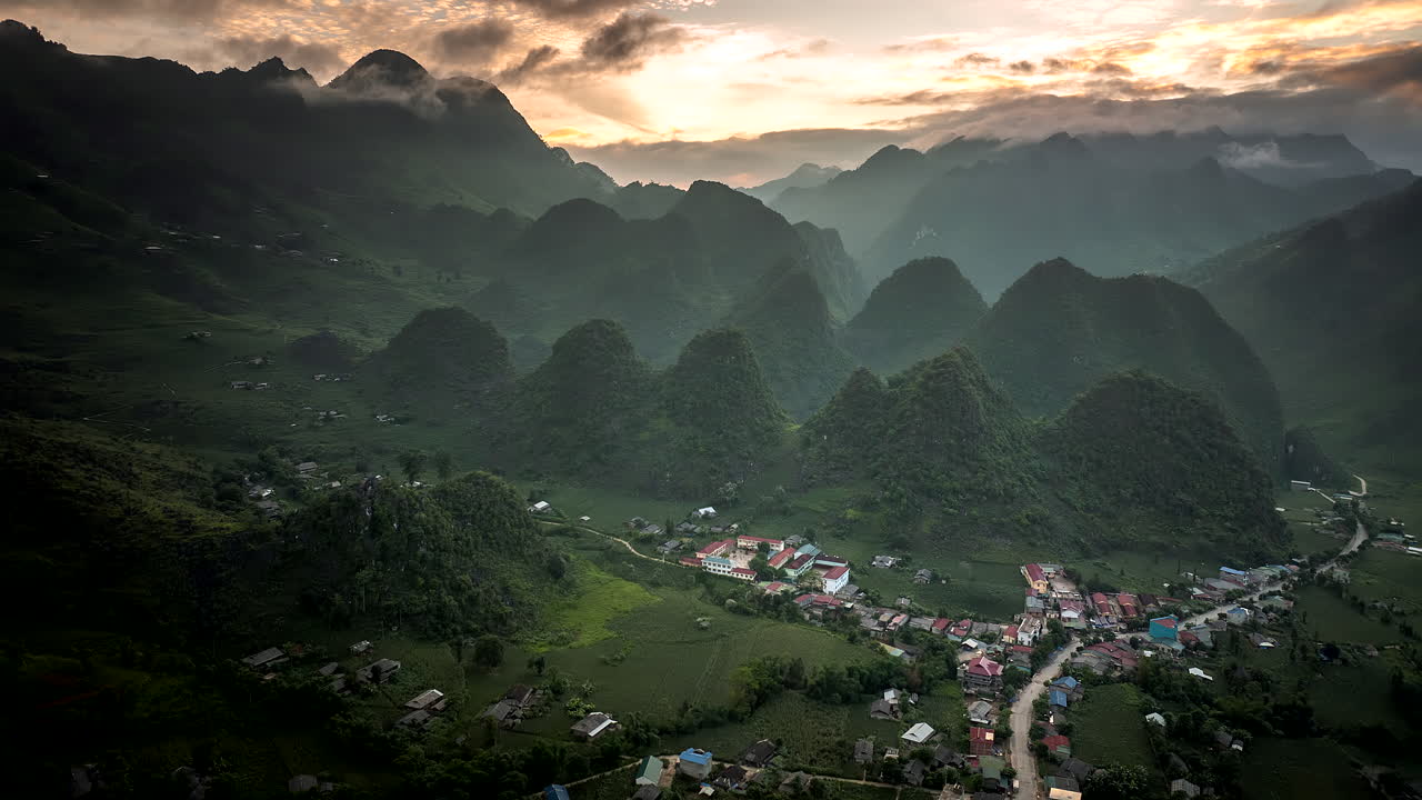Sunset drone hyperlapse over Lung Ho ethnic minority village in karst landscape
