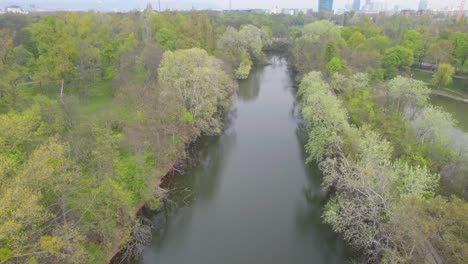 Toma-Aérea,-Drone-Volando-Sobre-El-Canal-Del-Río-En-El-Parque-Prater,-Viena,-Austria