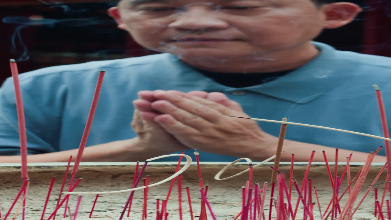 Asian Man Performing Ritual by Incense Burner