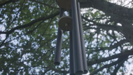 low angle shot of a wind chime moving in the wind creating beautiful sounds