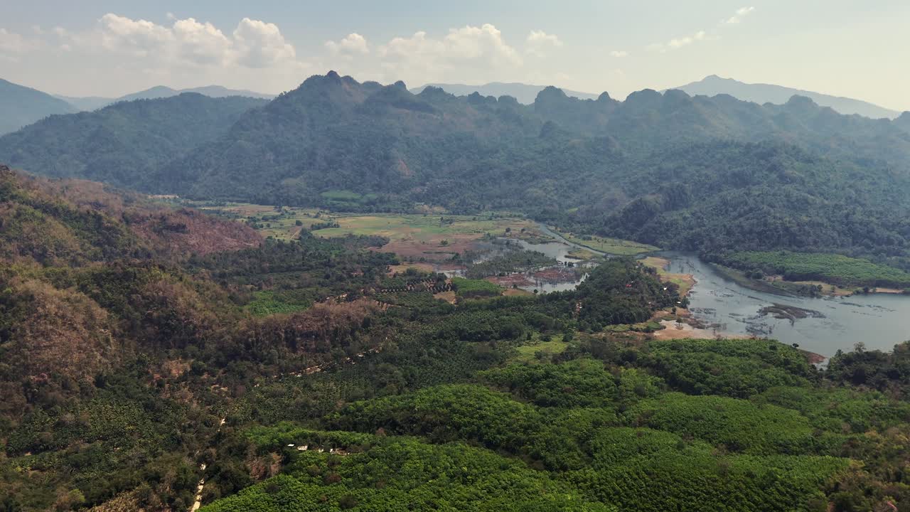 una vista de pájaro de una encantadora aldea enclavada entre las montañas en songklaburi, tailandia, retratando un entorno sereno y pintoresco