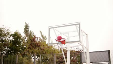 Tracking-shot-of-a-young-man-running-with-a-ball-and-throwing-a-ball-to-the-basket-successfully.-Basketball-game.-Slow-Motion