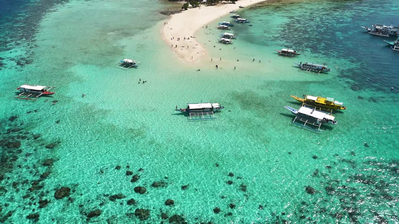 playa de una isla tropical con barcos y turistas