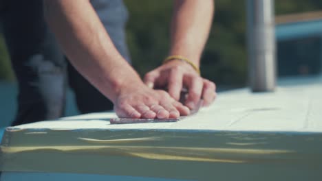 carpenters hands sanding roof planks of wooden boat slow motion
