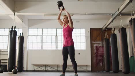 Colocar-Mujer-Caucásica-Haciendo-Ejercicio-Con-Campana-En-El-Gimnasio