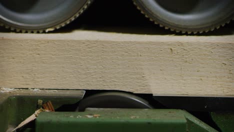 close up of industrial planer working on logs in a wood factory or sawmill.