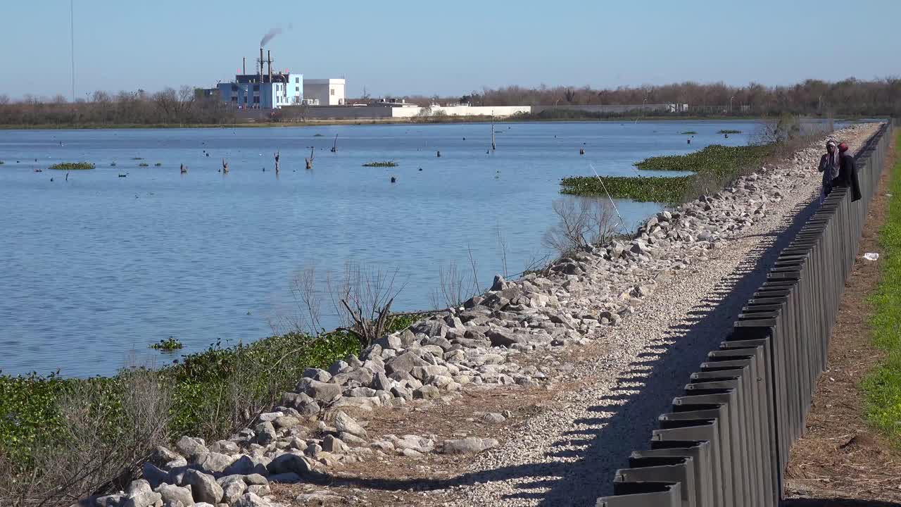 jóvenes adolescentes pasan el rato a lo largo de una pared junto a un impuesto en el distrito 9 de nueva orleans