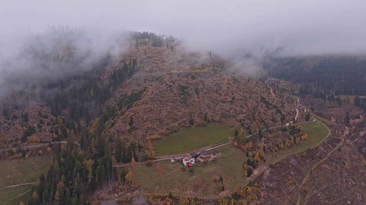 Strada di montagna tortuosa in Italia circondata dai colori autunnali, vista drone