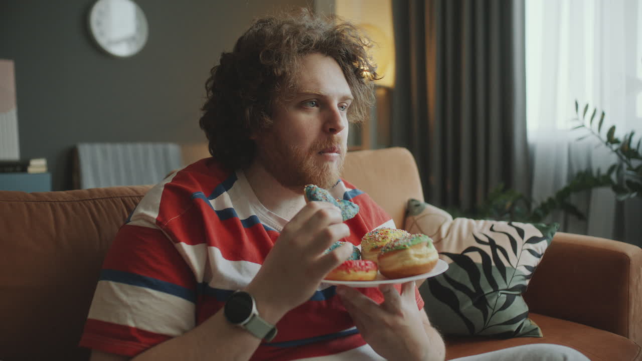 Man Eating Donuts on Couch