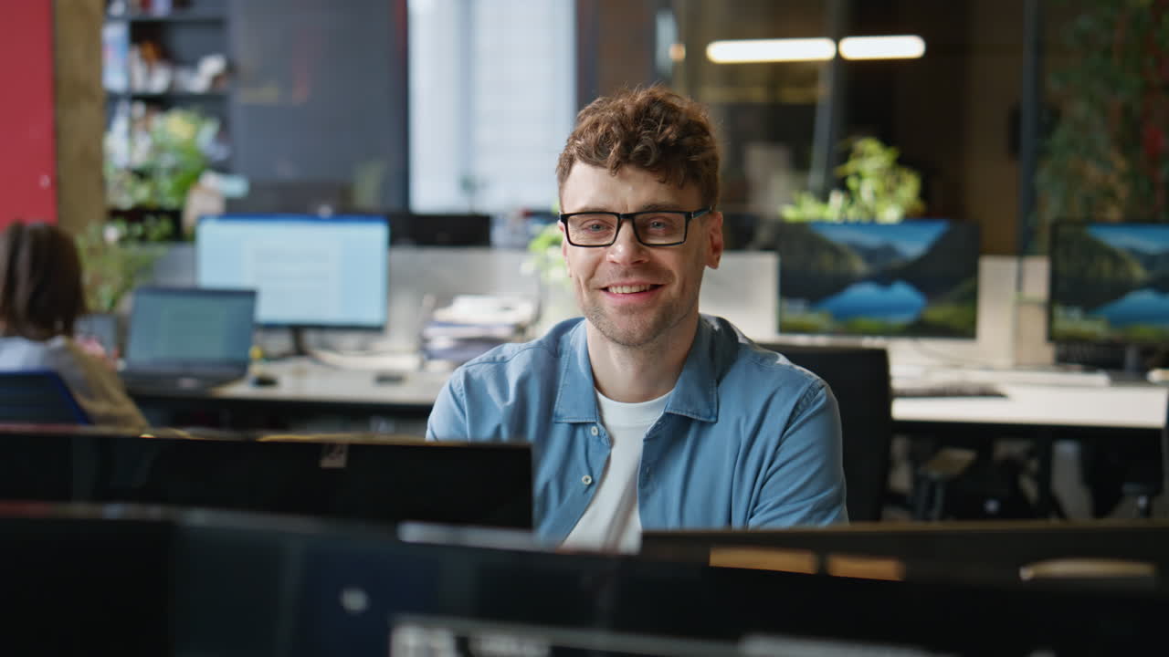 Eyeglasses guy corresponding client using computer at corporate office closeup