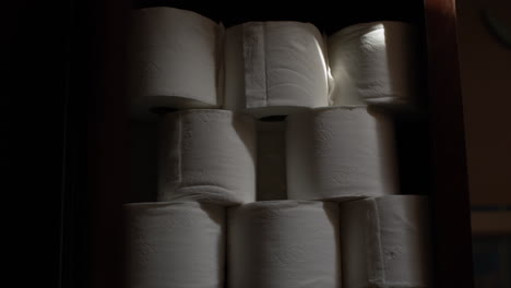 stabilized slow zoom out shot of a stack of toilet paper in a cupboard