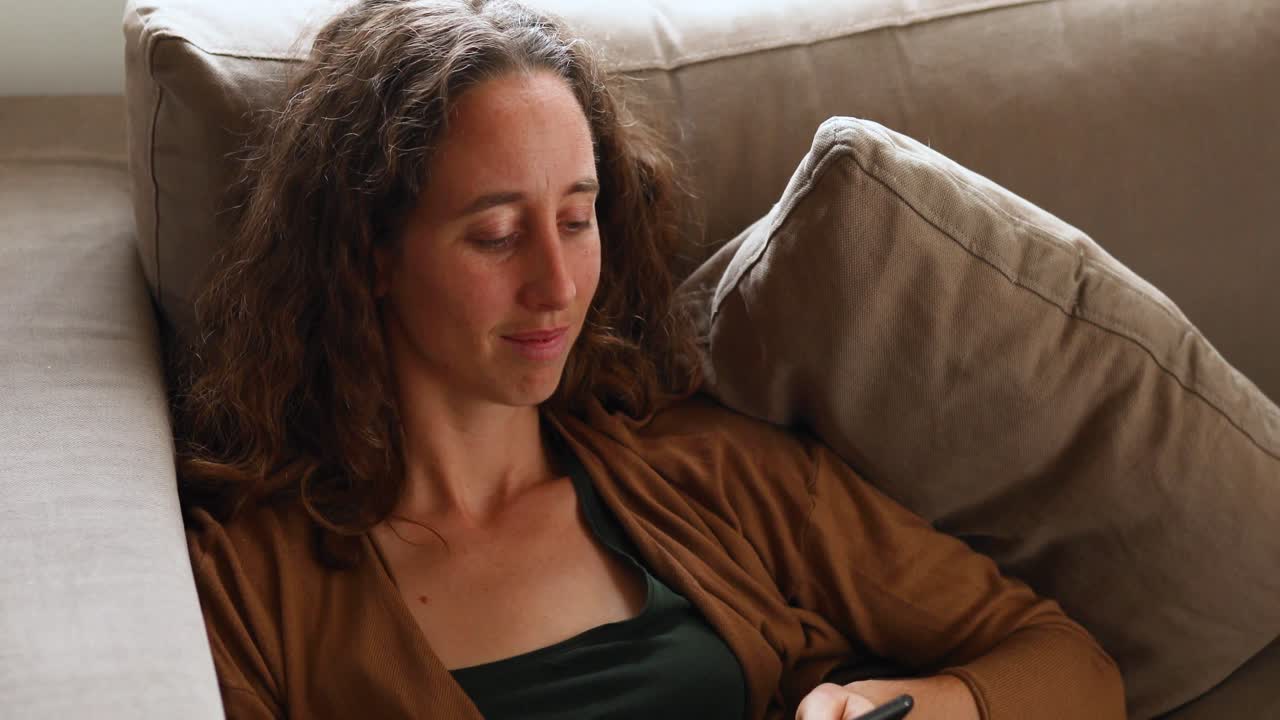 mujer caucásica usando su teléfono en casa