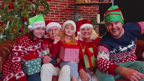 un hombre establece un temporizador en su teléfono móvil tomando un retrato de familia de varias generaciones celebrando navidad