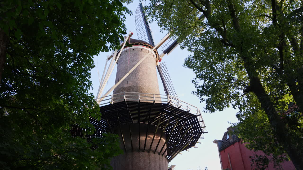 Molen 't Slot Behind Dense Tree Foliage In Gouda, Netherlands