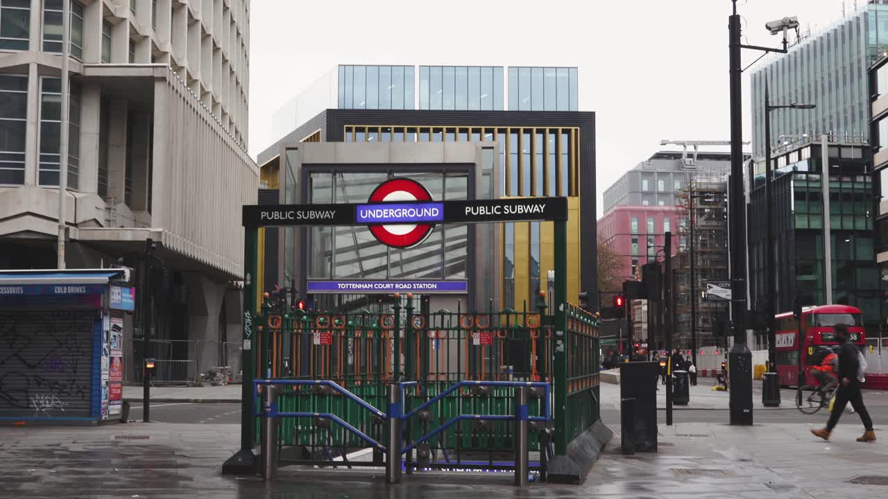 London - Empty Streets - Tottenham Court Road Underground Station closed with masked pedestrians and buses passing  (Covid-19 Pandemic, April 10, 2021)