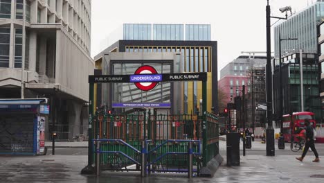 london - empty streets - tottenham court road underground station closed with masked pedestrians and buses passing  (covid-19 pandemic, april 10, 2021)