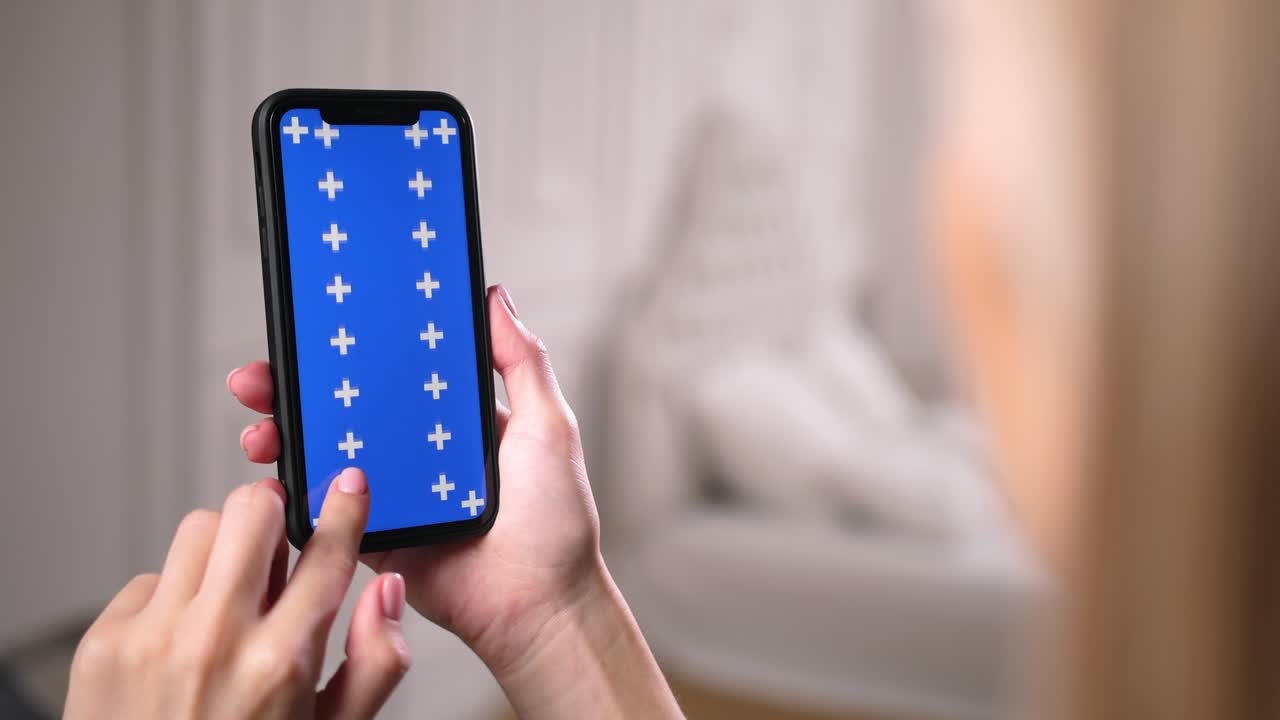 여성 슬라이드는 스마트폰 앱에서 파란색 크로마 키 스크린을 위아래로 스크롤합니다.