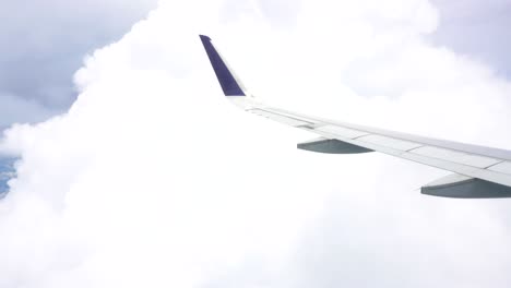 airplane wing above clouds during flight