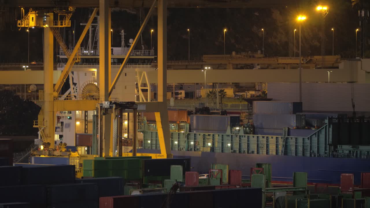 una vista nocturna de un barco de carga cargando en el puerto de barcelona