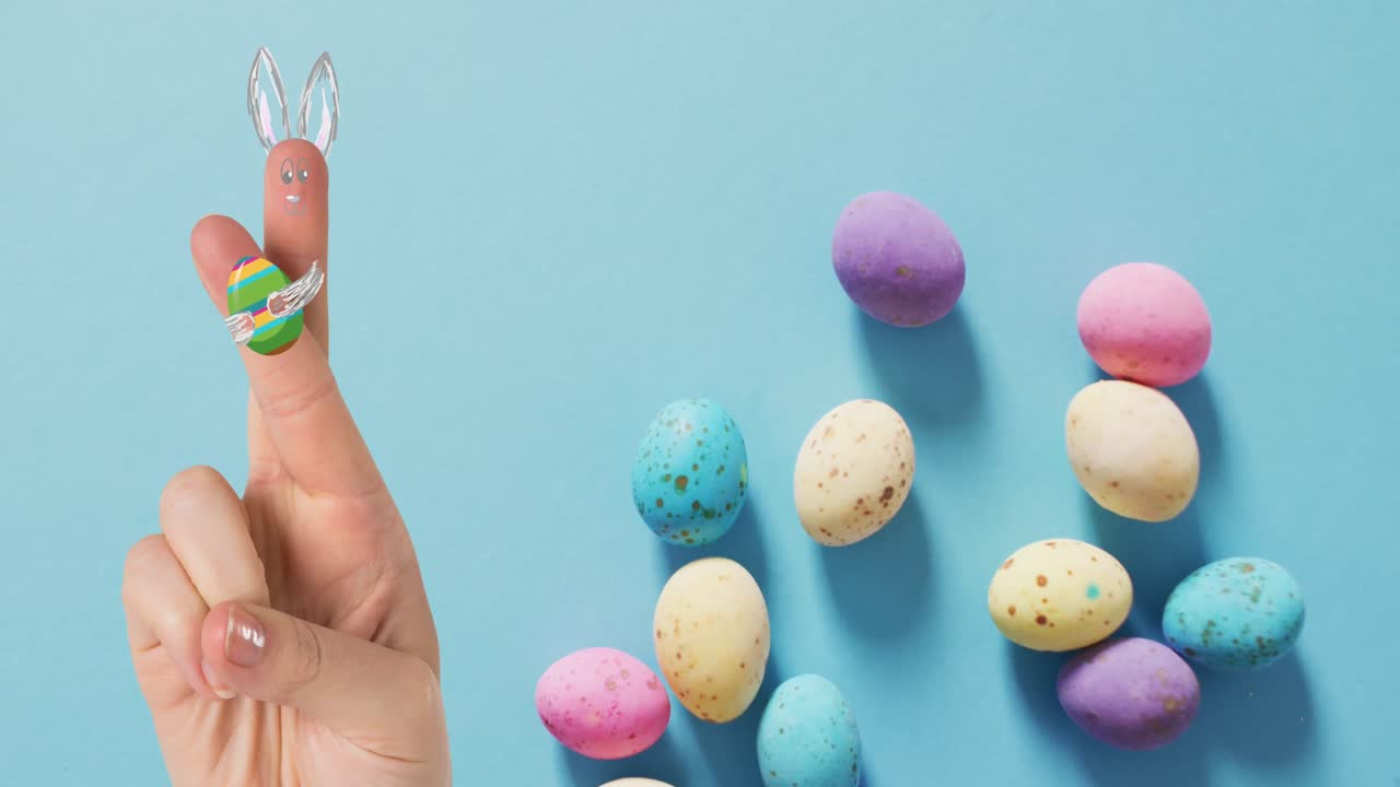 анимация руки с пасхальными украшениями и пасхальными яйцами на синем фоне