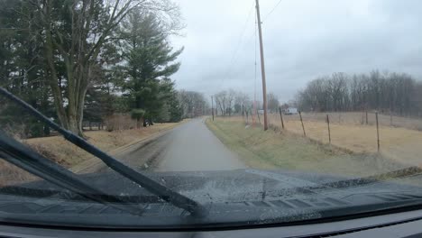 POV-Durch-Die-Windschutzscheibe-Und-Aktive-Scheibenwischer-Bei-Leichtem-Regen-Während-Der-Fahrt-Auf-Einer-Kreisstraße-Im-Ländlichen-Illinois-Im-Zeitigen-Frühjahr