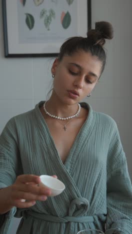 woman in robe drinking tea