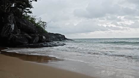 Entsättigte-Aufnahme-Von-Wellen,-Die-An-Sandiger-Küste-Und-Felsen-Am-Strand-Von-Dam-Trau,-Vietnam,-Zusammenbrechen