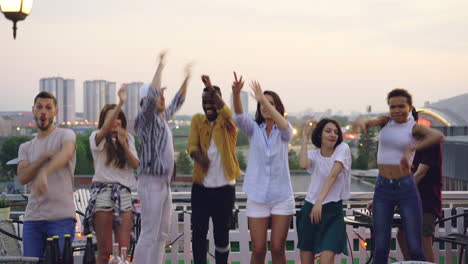 friends dancing on a rooftop party
