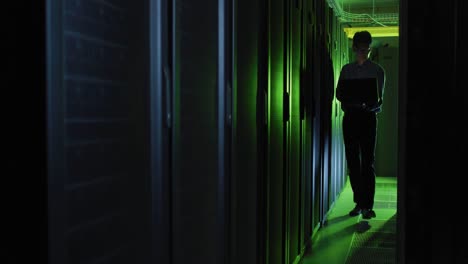 Asian-male-it-technician-using-laptop-checking-computer-server