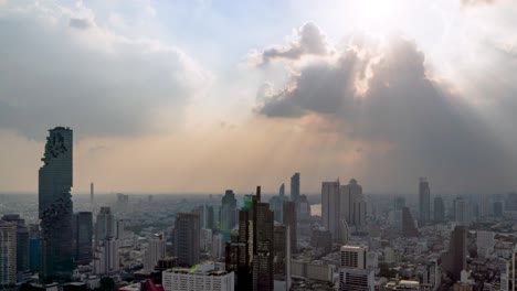 sunburst or sun rays or god light beam through the cloud over bangkok business district city center above silom area – time lapse