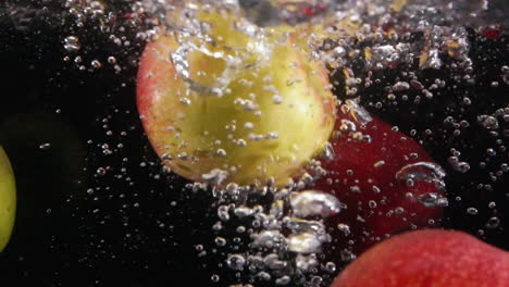 slow motion dropping apples falling into in water in sink with bubbles preparing to cook