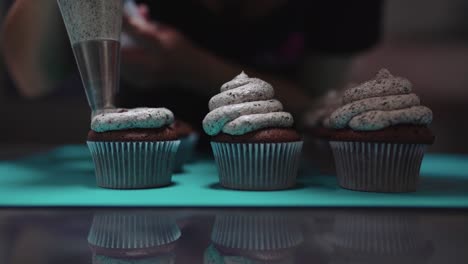 person squeezing cream on muffins