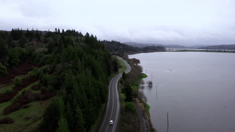 Vista-Aérea-De-La-Ruta-42-De-Oregon-Que-Conecta-Coos-Bay-Y-Coquille-En-Oregon-Con-Pastos-Inundados-Junto-A-La-Carretera-Asfaltada-Después-De-La-Lluvia