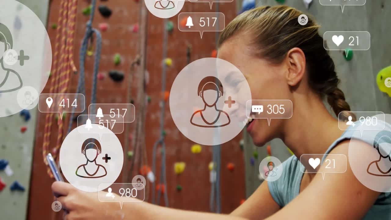 iconos de las redes sociales flotando contra una mujer caucásica que usa un teléfono inteligente en el gimnasio