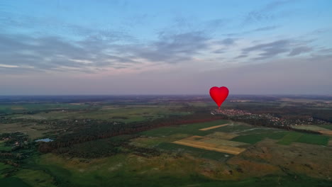 red air balloon in love heart shape. panoramic view on nature landscape and beautiful hot air balloon. bright aerostat flying over the fields.