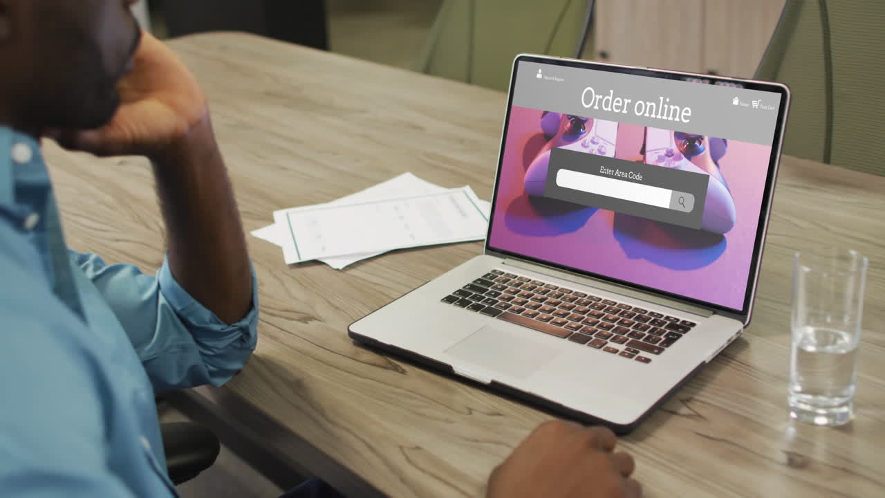 African american man using laptop, online shopping for gamepads, slow motion