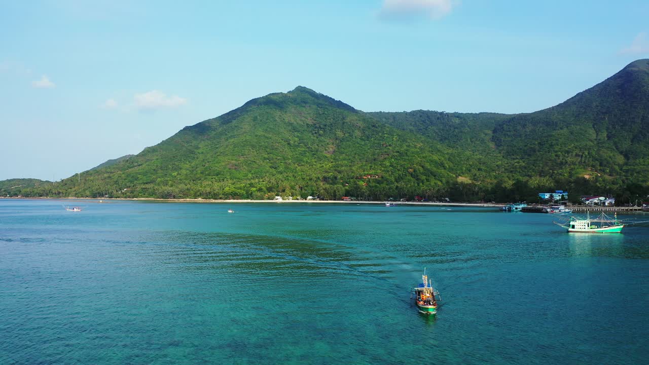Boats in the calm Thailand lagoon. Mountains and hills sandy beach on the island coast