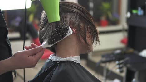 hairdresser with hair dryer at work. beauty saloon. shot in slowmotion