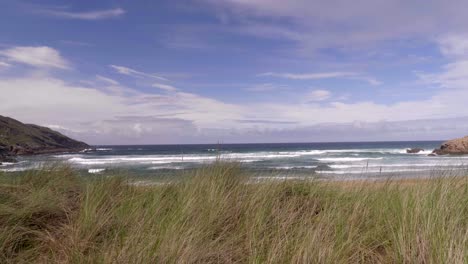 Impresionante-Paisaje-Del-Océano-Con-Olas-Bajo-El-Cielo-Azul-Brillante-En-La-Isla-De-La-Playa-De-Las-Cuevas,-Donegal,-Irlanda