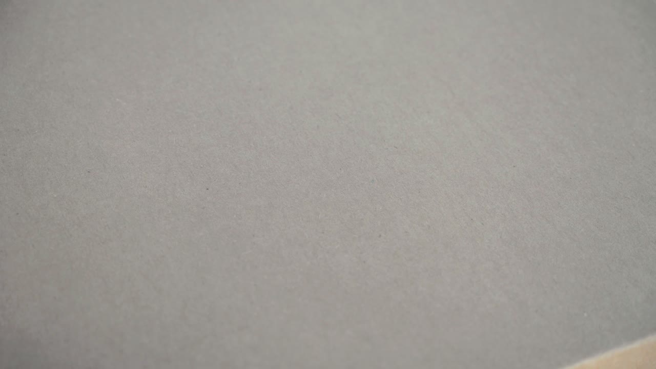Close-up abrindo uma caixa de pizza de papelão com uma saborosa pizza napolitana recém-assada com molho pesto sobre a mesa.