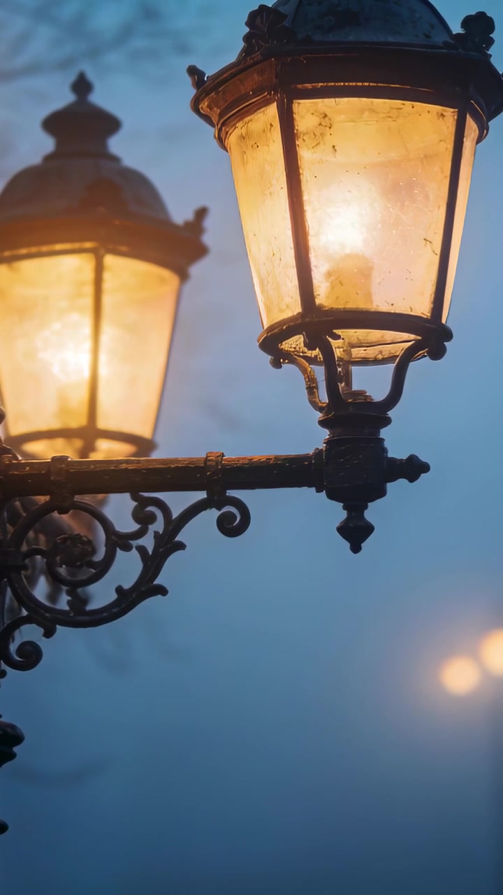 Video verticale: Telecamera panoramica che avvicina un lampione in ferro nella nebbia per mostrare la lanterna anteriore, con un bagliore.