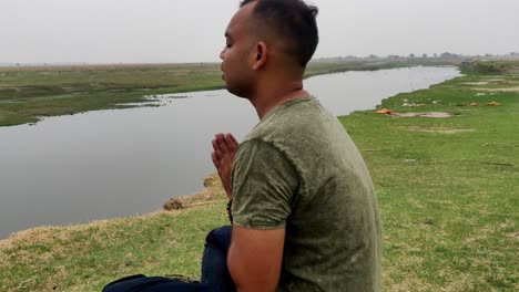 an asian boy praying and meditating with folded hands