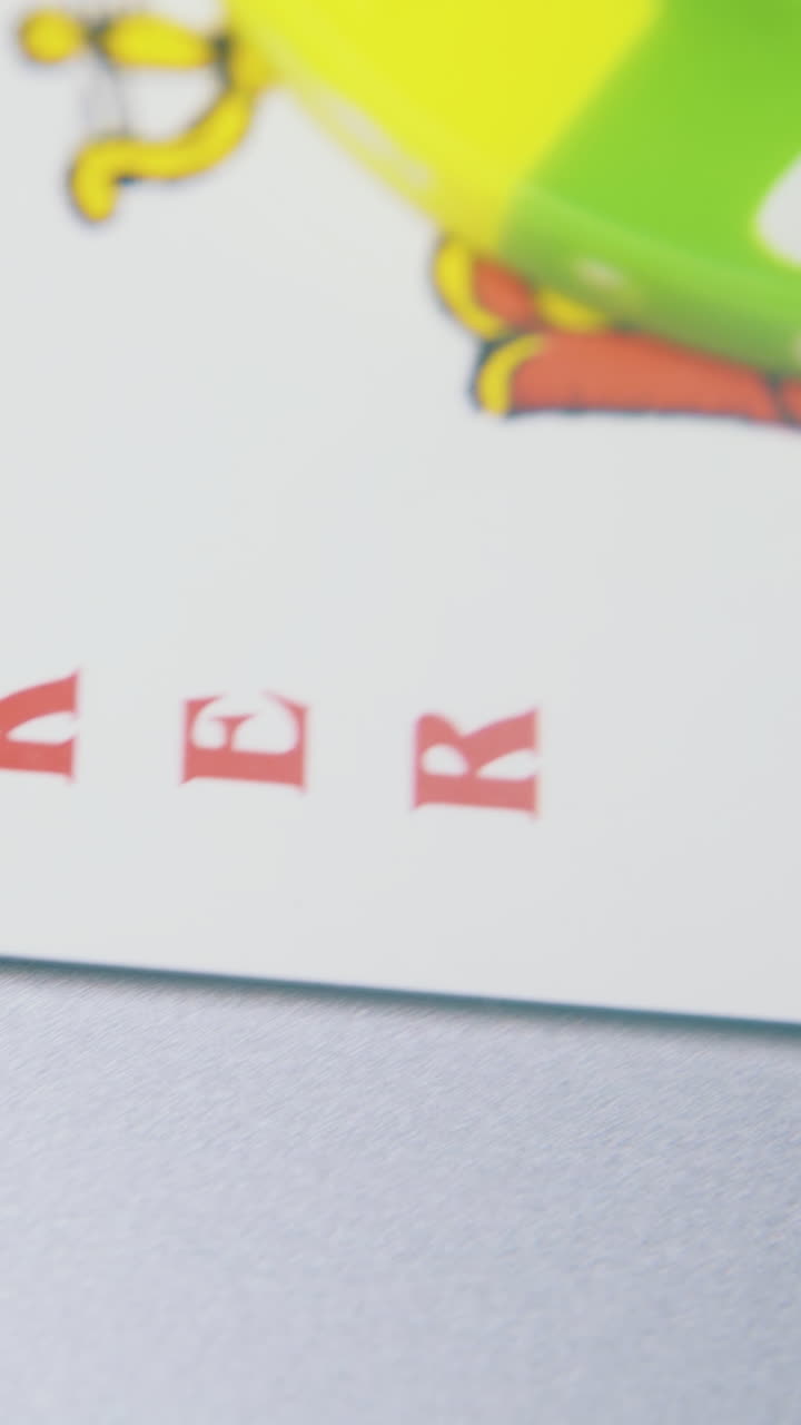 scattered bright green casino chips and joker playing card on light grey background extreme close view