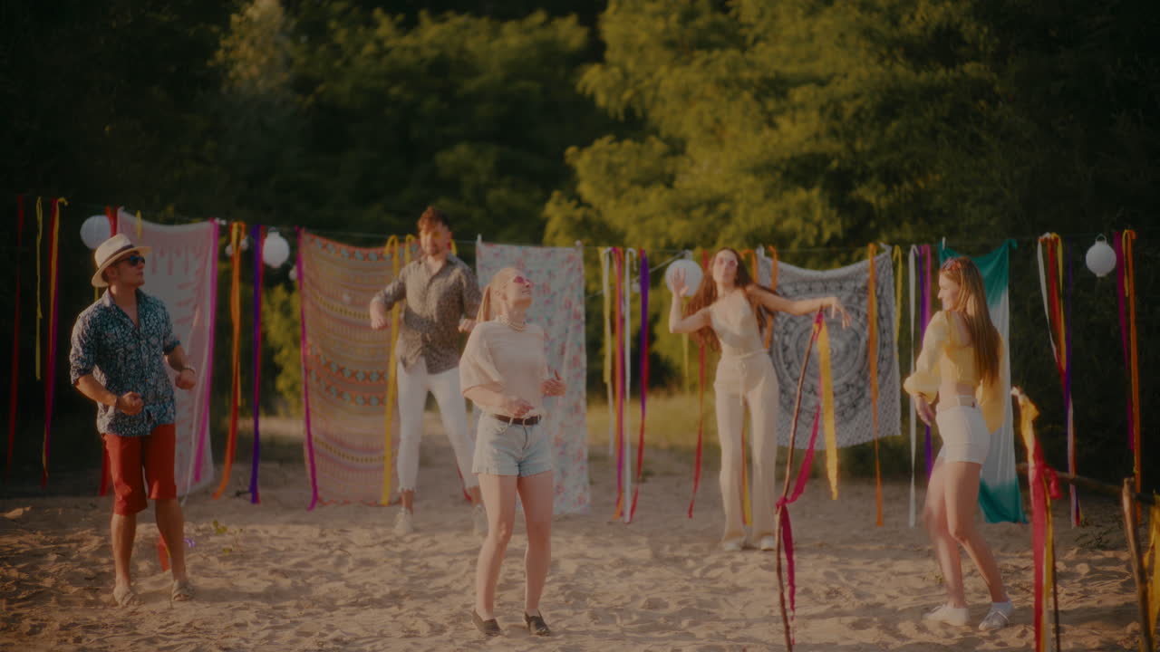 해가 지는 동안 해변에서 함께 놀고 있는 행복한 친구들