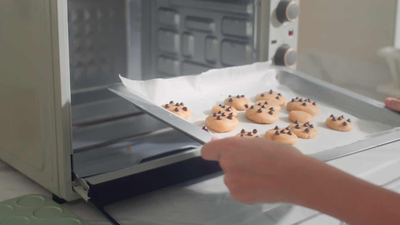 Girl Setting Oven Temperature when Baking Cookies