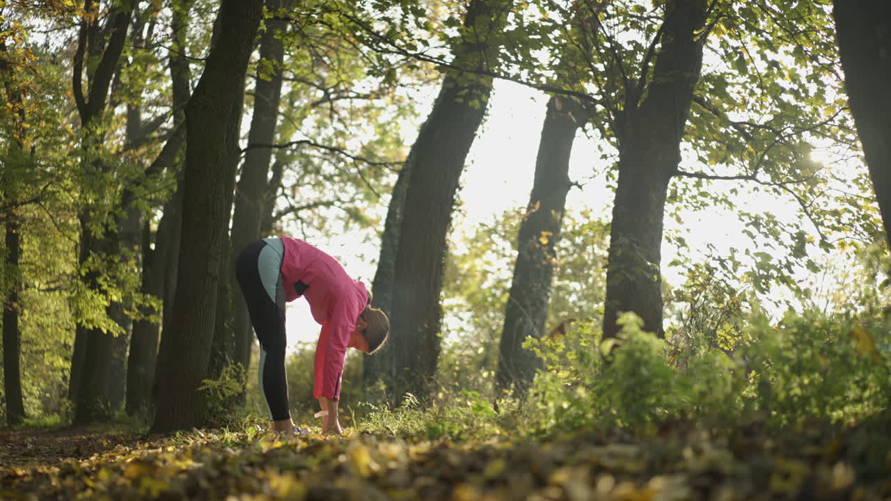 mujer estirándose en el parque de otoño